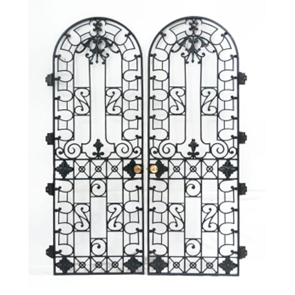 Pareja de puertas en hierro en forma de capilla con decoración geométrica, vegetal y flores con tiradores en metal.   Época: Mediados S. XX
