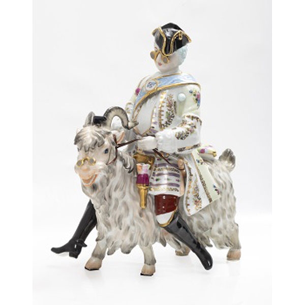 Figura en porcelana policromada y dorada representando personaje de corte a lomos de una cabra