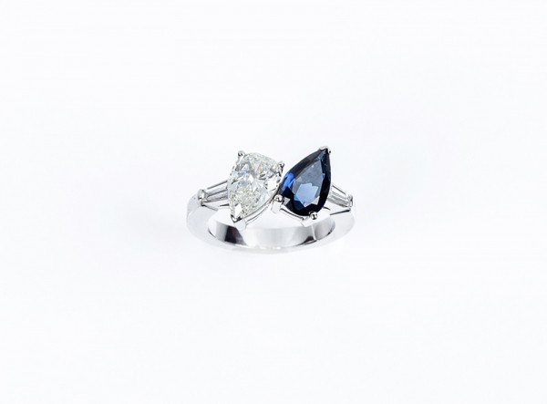 Anillo &#039;tú y yo&#039; de alta joyería con un bello zafiro fino azul y un blanco y limpio diamante, ambos en talla perilla.