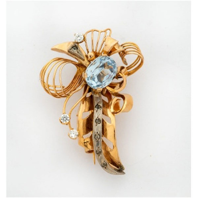 Broche Chevalier en oro amarillo en forma de ramo con piedra azul central y diamantes.