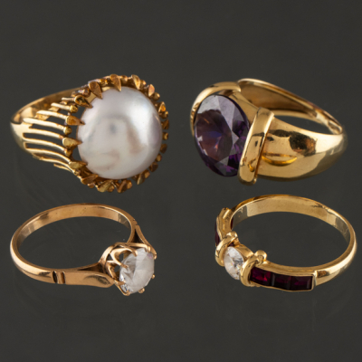 Conjunto de cuatro anillos en oro amarillo de 18 kt. con amatista, perla japonesa y rubíes.