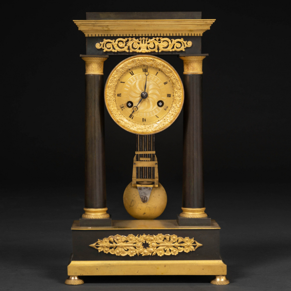 Reloj de sobremesa francés época Imperio de dos columnas en bronce pavonado y bronce dorado del siglo XIX