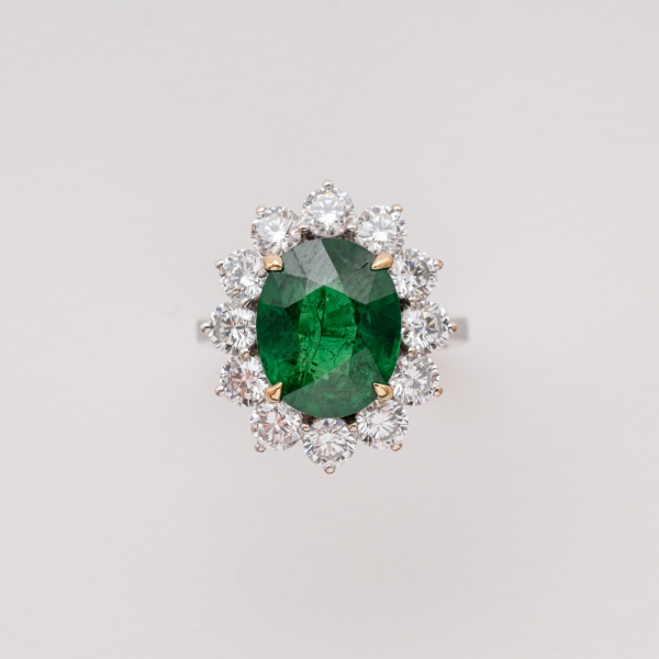 Sortija rosetón en oro blanco con tsavorita talla oval orlada por diamantes talla brillante.