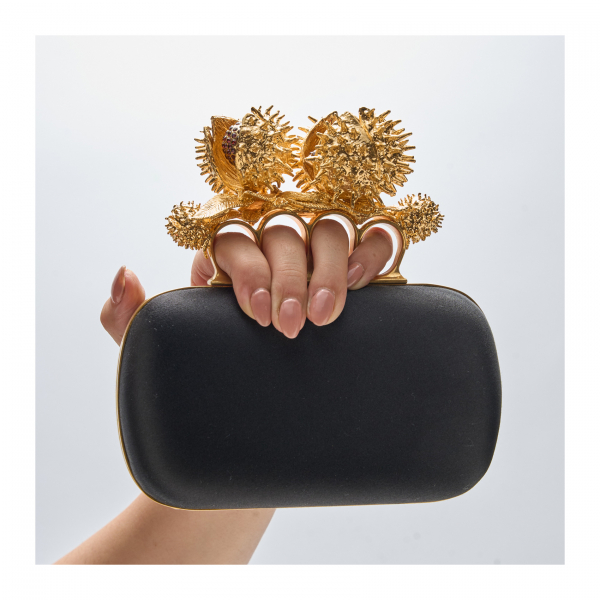 ALEXANDER MC.QUEEN. Bolso modelo «New Knukle Duster» en raso negro y asa de empuñadura en metal dorado con pedrería. Nuevo.