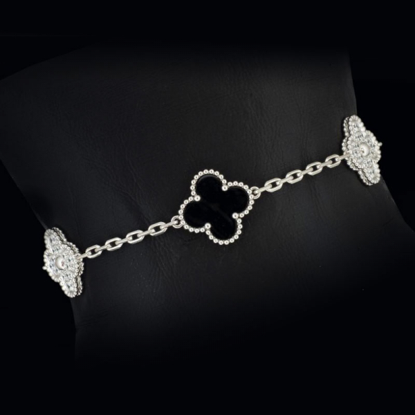 Pulsera de oro blanco de 18 K. marca VAN CLEEF& ARPELS, con flores de onix y diamantes.