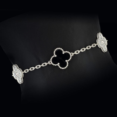 Pulsera de oro blanco de 18 K. marca VAN CLEEF&amp; ARPELS, con flores de onix y diamantes.