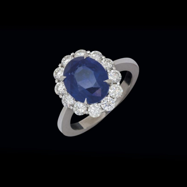 Anillo de oro blanco de 18 K. con zafiro azul talla oval de 4,98 cts. orlado por brillantes  de un peso total de 1,05 cts.