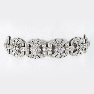 Elegante brazalete &#039;decó&#039;, años 40, en oro blanco 18 K con 10 eslabones en rosetón y bandas caladas de limpios y blancos diamantes 