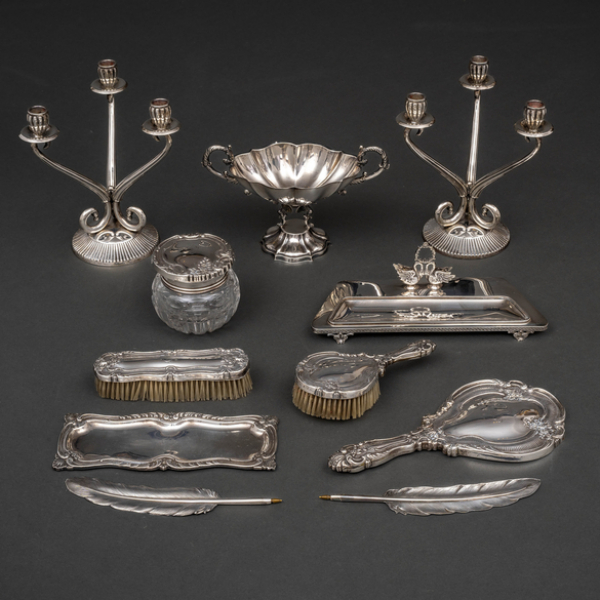 Conjunto de escribanía, pareja de candelabros, juego de tocador y centro en plata española y punzonada del siglo XX.