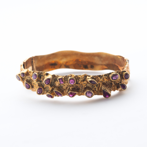 Pulsera esclava en oro con frente de textura rugosa estilo org&aacute;nico y granates en diversas tallas y medidas engastados en chat&oacute;n.