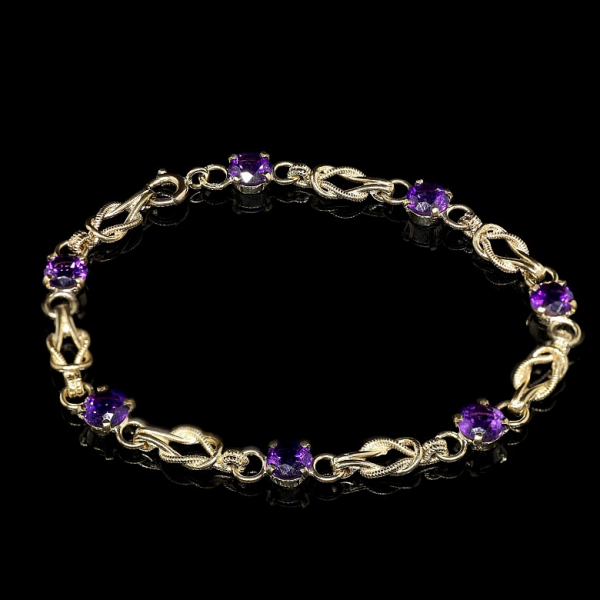 Pulsera de oro amarillo 9K con eslabones entrelazados y amatistas. 