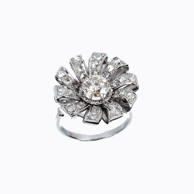 Bella sortija vintage en forma de flor, en platino, con un limpio y blanco diamante natural central, talla brillante 