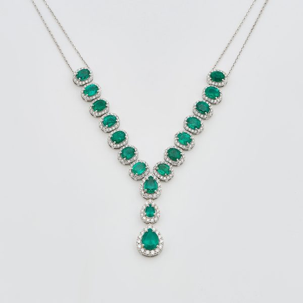 Gargantilla en oro blanco con rosetones de esmeraldas colombianas tallas oval y perilla orladas por diamantes talla brillante. 