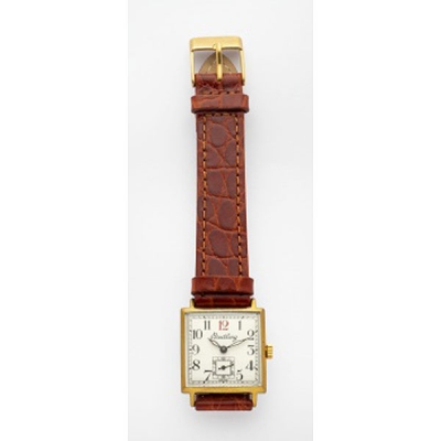 Reloj de caballero marca Breitling con caja en acero y chapado, esfera blanca, números árabes y correa en piel marrón.