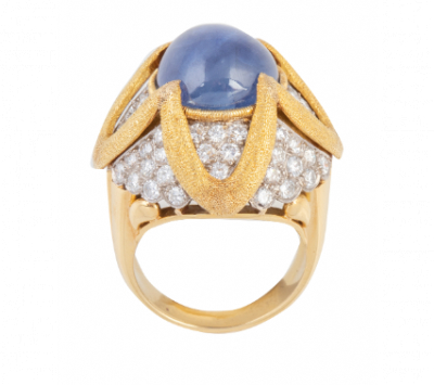 Sortija bombée con cabujón de zafiro Ceylán central de 17 ct, cuajada de brillantes y decorada con flor de hilos de oro mate. 
