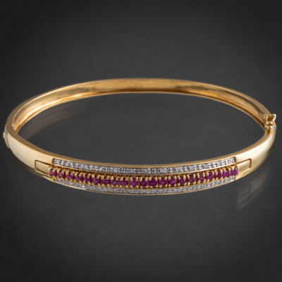 Bonita pulsera r&iacute;gida con banda de brillantes y rub&iacute;es en oro amarillo de 18 kt.