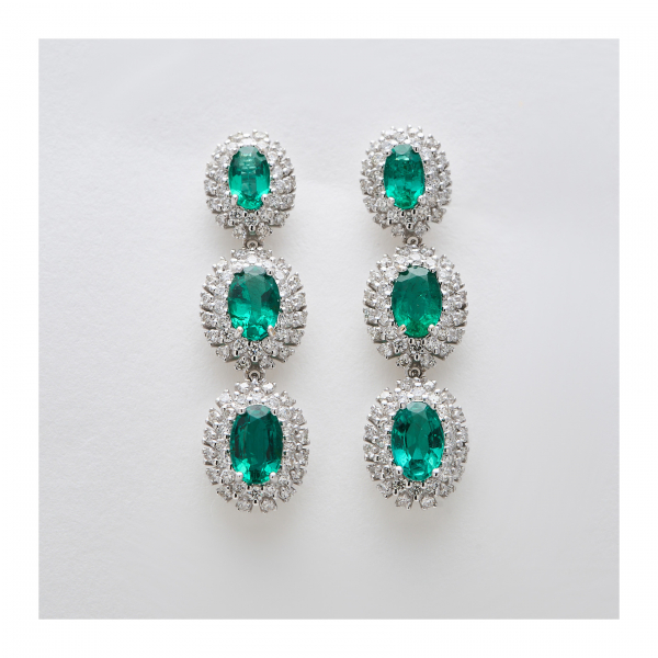 Pendientes largos con tres rosetones de esmeralda talla oval orlada por diamantes talla brillante.