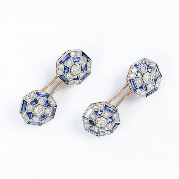 Delicados gemelos de época 'art-decó', en montura calada de oro amarillo con botones octogonales ajedrezados, con un limpio y blanco diamante talla brillante antigua orlado de piedras azules calibradas y limpios y blancos diamantes talla 8/8, sobre vistas grafiladas de platino.