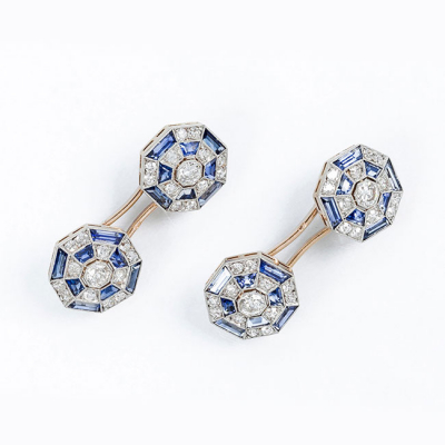 Delicados gemelos de época &#039;art-decó&#039;, en montura calada de oro amarillo con botones octogonales ajedrezados, con un limpio y blanco diamante talla brillante antigua orlado de piedras azules calibradas y limpios y blancos diamantes talla 8/8, sobre vistas grafiladas de platino.