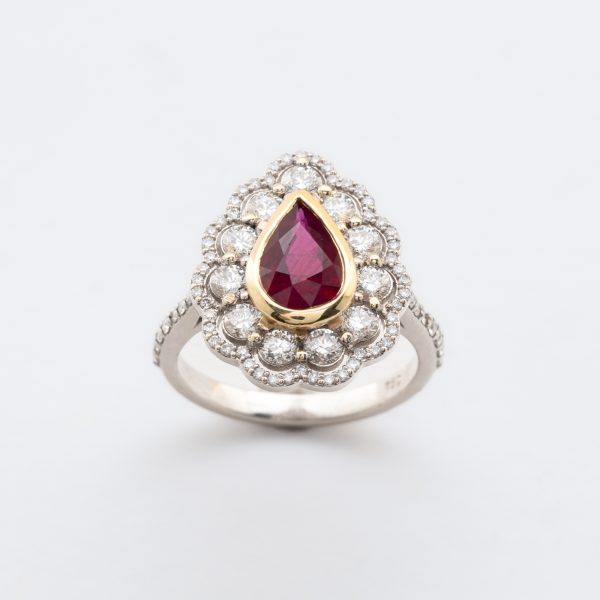 Sortija rosetón en oro bicolor con rubí talla perilla y dos orlas y brazos de diamantes talla brillante.