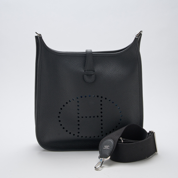 HERMÈS. Bolso modelo «Evelyn 29» en piel negra calada con cierre de click. Nuevo a estrenar con etiqueta y plásticos protectores, 2024.