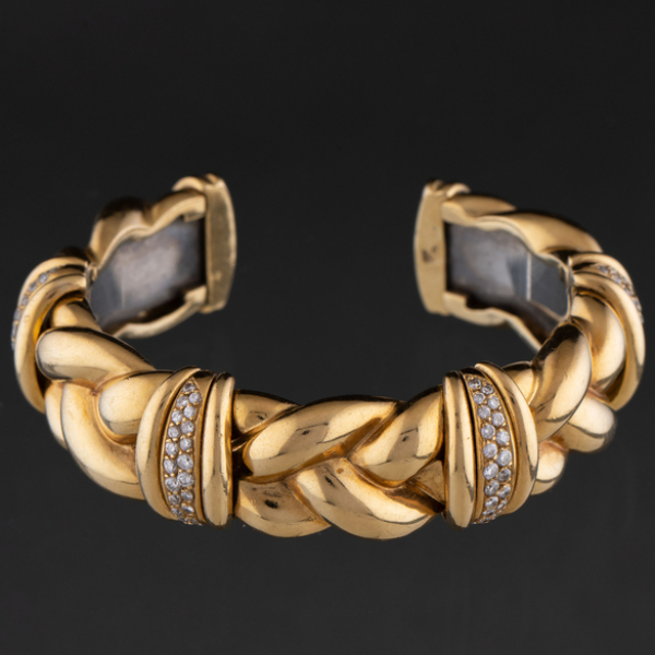 Pulsera articulada en oro amarillo de 18 kt con forma entrelazada con bandas de brillantes.