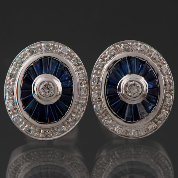 Bonita pareja de pendientes en oro blanco de 18 kt en forma ovalada orlados de brillantes y zafiros calibrados.