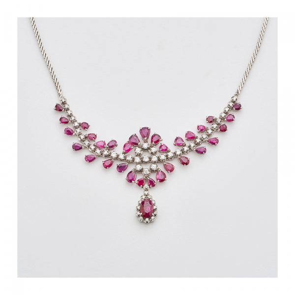Gargantilla en oro blanco con tira central de diamantes talla brillante custodiada por rubíes tallas perilla y trillón  