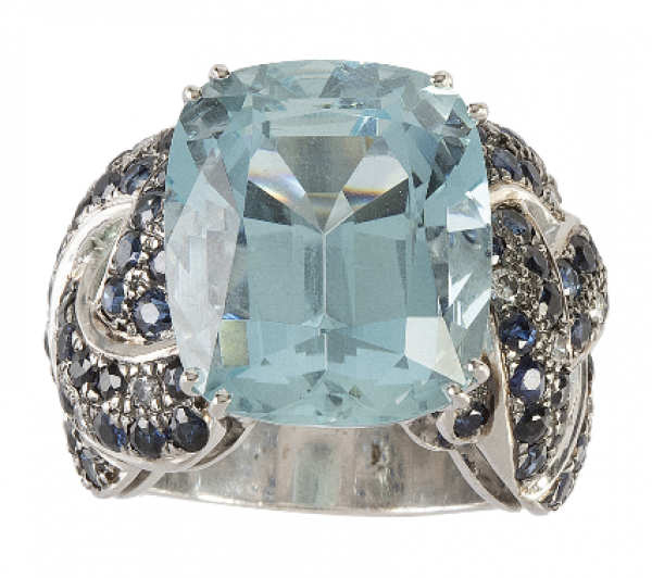 Sortija con gran aguamarina central de intenso color en talla coj&iacute;n, con montura de bandas trenzadas de zafiros adornadas con brillantes. 