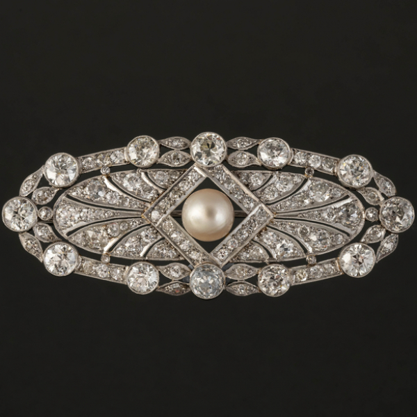 Broche antiguo en oro blanco de 18kt cuajado de brillantes talla antigua con perla en el centro.