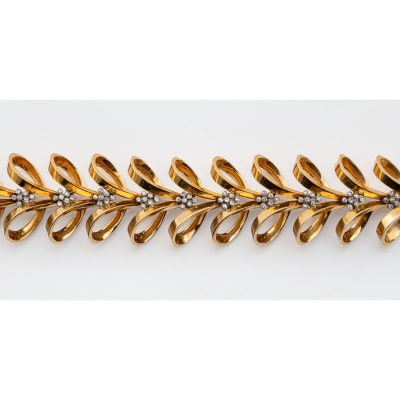 Brazalete en oro bicolor con lazadas y conjuntos de diamantes talla 8/8 engastados en chatón. 