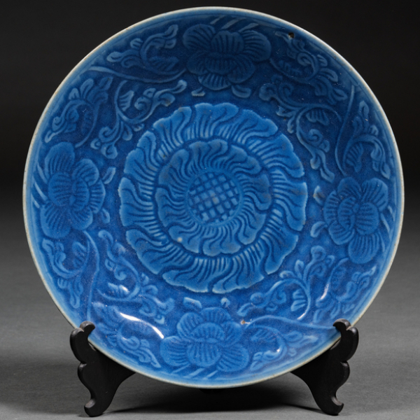 Plato circular en porcelana china color azul con decoración de flor de loto. S. XIX