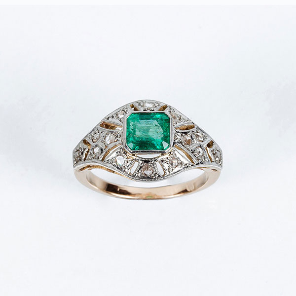 Sortija vintage en oro amarillo 18 K con una bonita esmeralda colombiana, en su talla, sobre motivo geométrico 'decó' en celosía calada con limpios y blancos diamantitos, talla simple, en vistas grafiladas de platino.