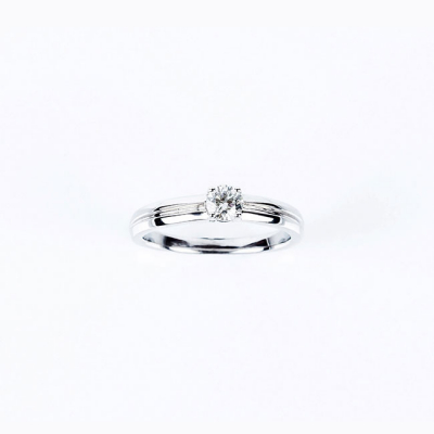Anillo solitario en oro blanco, con un un limpio y blanco diamante talla brillante de 0.25 ct aprox, en garras