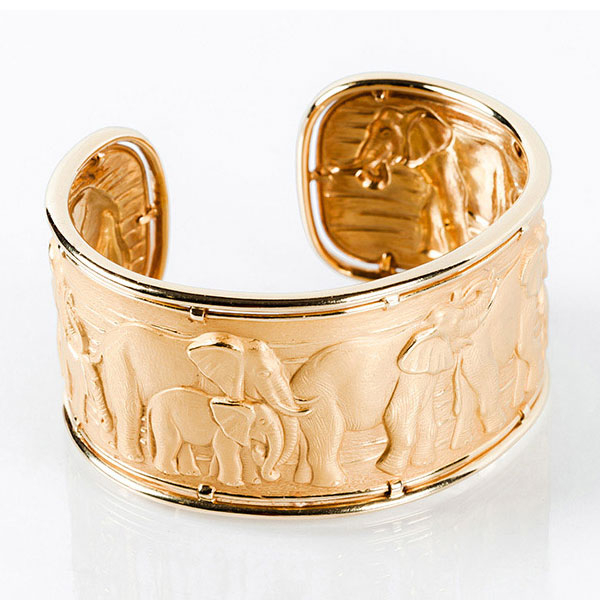 Brazalete esclavo de alta joyería Carrera y Carrera en oro amarillo 18K con relieve de elefantes y detalles en oro pulido