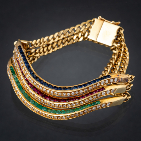 Pulsera de tres aros en oro amarillo de 18 kt con brillantes y zafiros, esmeraldas y rubíes calibrados.