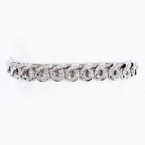 Elegante brazalete firmado por DAMIANI, en sólida montura de oro blanco que forma motivos espirales cuajados en filas de limpios y blancos diamantes talla brillante