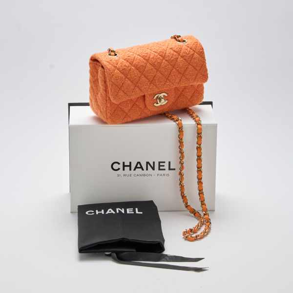 CHANEL. Bolso modelo «Classic Flap» en tweed de tonalidad naranja con cierre de pasador. Nuevo a estrenar con plásticos protectores, 2024.