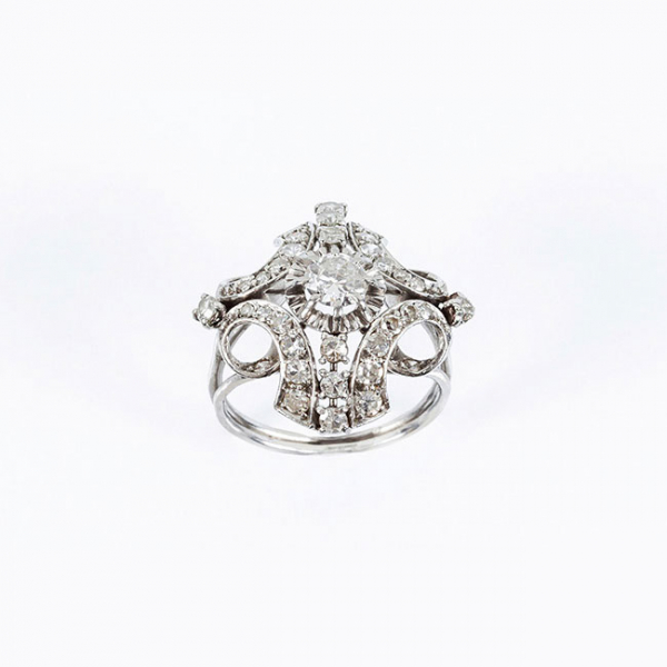 Bella sortija vintage 'art-decó' en platino, formando un rosetón con diamante natural central, talla brillante,  