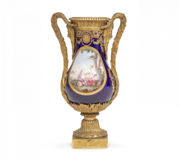 Jarr&oacute;n de porcelana esmaltado en azul real y dorado, con cartelas con escenas galantes, montado en bronce dorado. Con marcas en azul cobalto en la base con las letras BB insertas en dos "L" entrelazadas y las letras ch. S&eacute;vres, mediados del S. XVIII. 