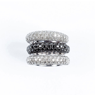 Conjunto de alta joyer&iacute;a formado por tres anillos en s&oacute;lida montura de oro blanco, con frente en pav&eacute; de diamantes, talla brillante, blancos en dos de ellos y negros en el otro. 180 bts blancos: 3.00 ct aprox