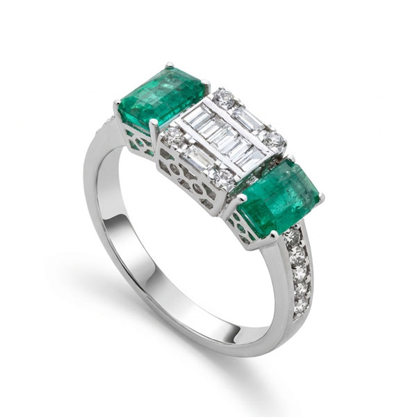 Sortija en oro blanco con 2 esmeraldas, brillantes talla baguette centrales y brazos con diamantes talla brillante con un peso total de 0,75 cts.