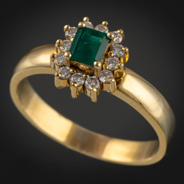 Anillo en oro amarillo de 18 kt con esmeralda y orla de brillantes.