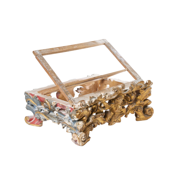 Atril en madera tallada, dorada y policromada con decoraciones de roleos, acantos y angelote frontal, fles. del s.XVIII.