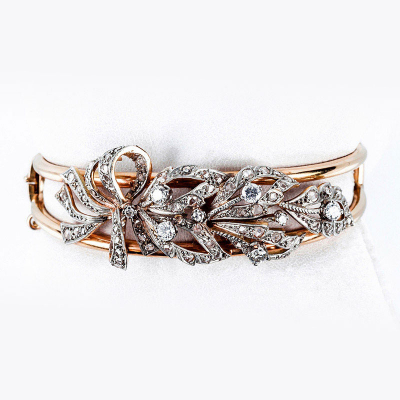 Brazalete esclavo vintage en &#039;esqueleto&#039; de oro amarillo 18 K, con lazada vegetal decorado con limpios y blancos diamantes 