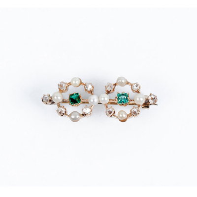 Alfiler vintage en oro rosa con dos centros de bonitas esmeraldas en su talla, orlada de limpios y blancos diamantes  