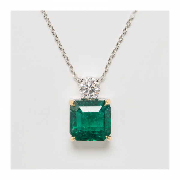 Colgante en oro blanco con esmeralda de Zambia talla octogonal coronada por diamante talla brillante.