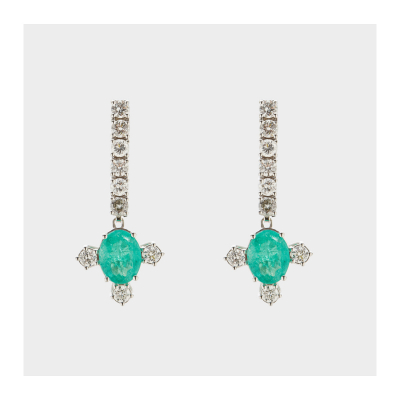Pendientes largos en oro blanco con tira de diamantes talla brillante rematada por esmeralda talla oval flanqueada por tres diamantes.