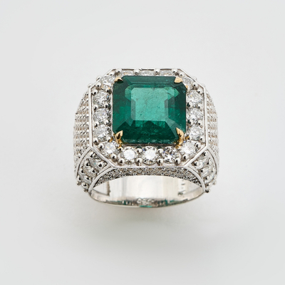 Sortija diseño sello en oro bicolor con esmeralda central talla octogonal y cuerpo cuajado de diamantes talla brillante.