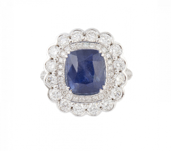 Sortija con zafiro birmano talla cojín de 6,15 ct en doble orla de brillantes, la exterior en marco lobulado.   En oro blanco de 18K.